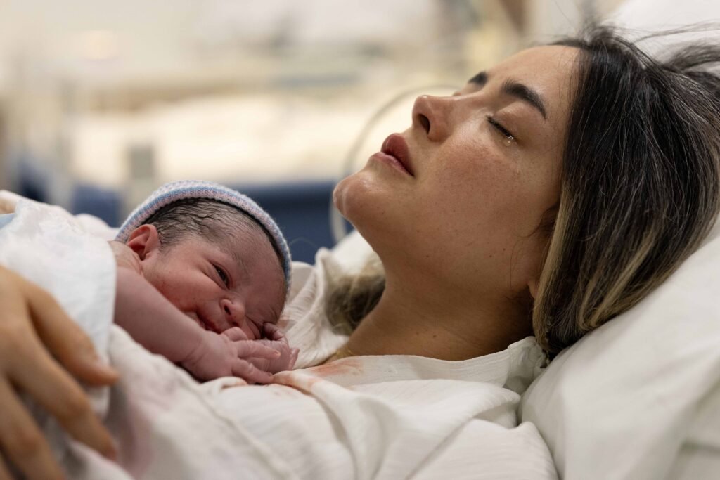 Mother holding newborn baby skin-to-skin moments after birth in The Hague hospital.