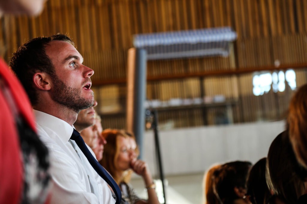 Audience member reacting with fascination during a conference presentation in The Hague.