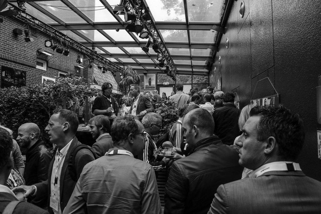 Large group of professionals networking at a lively indoor event in The Hague.