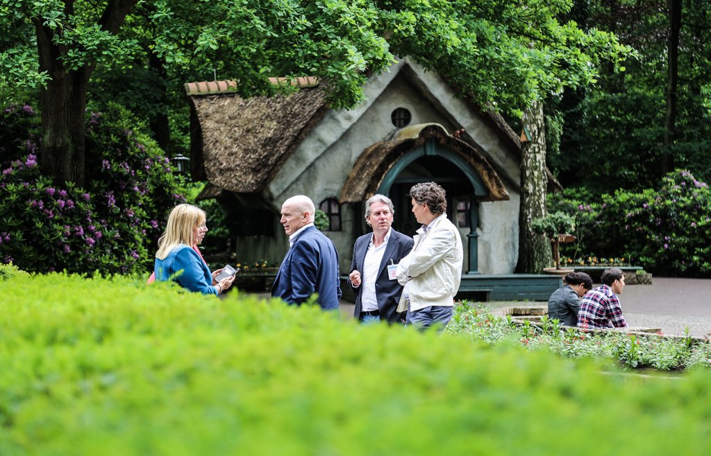 Professionals having an outdoor business conversation in a garden setting near The Hague.
