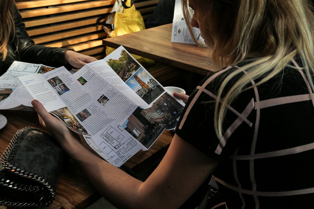 Business event attendee reading an informational brochure during a conference in The Hague.