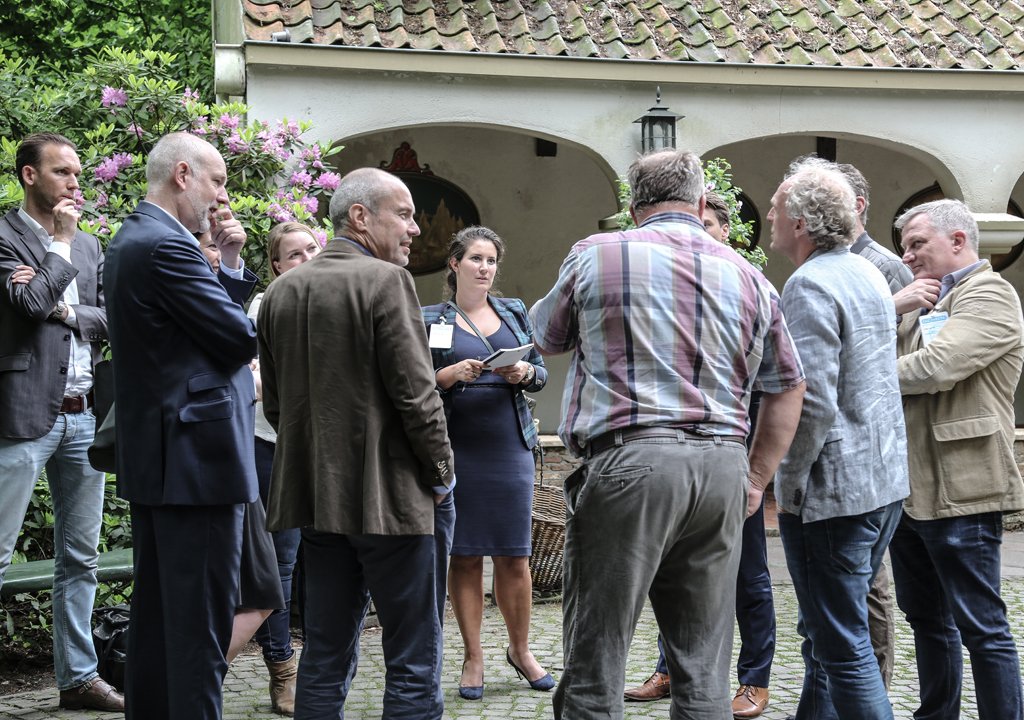 Group of professionals in discussion during an outdoor business event in The Hague.