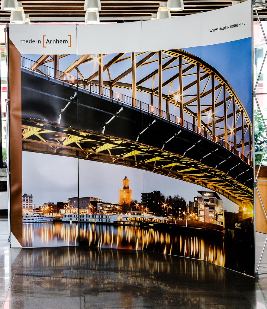 Large exhibition stand featuring a printed backdrop of Arnhem at a conference in The Hague.