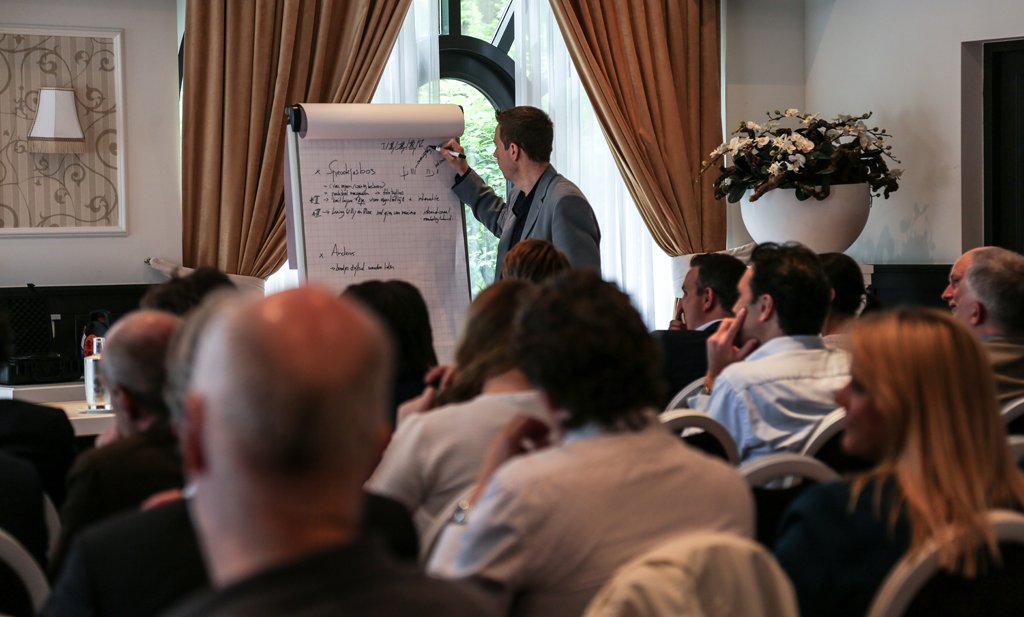 Workshop leader writing on a flipchart during a corporate training session in The Hague.
