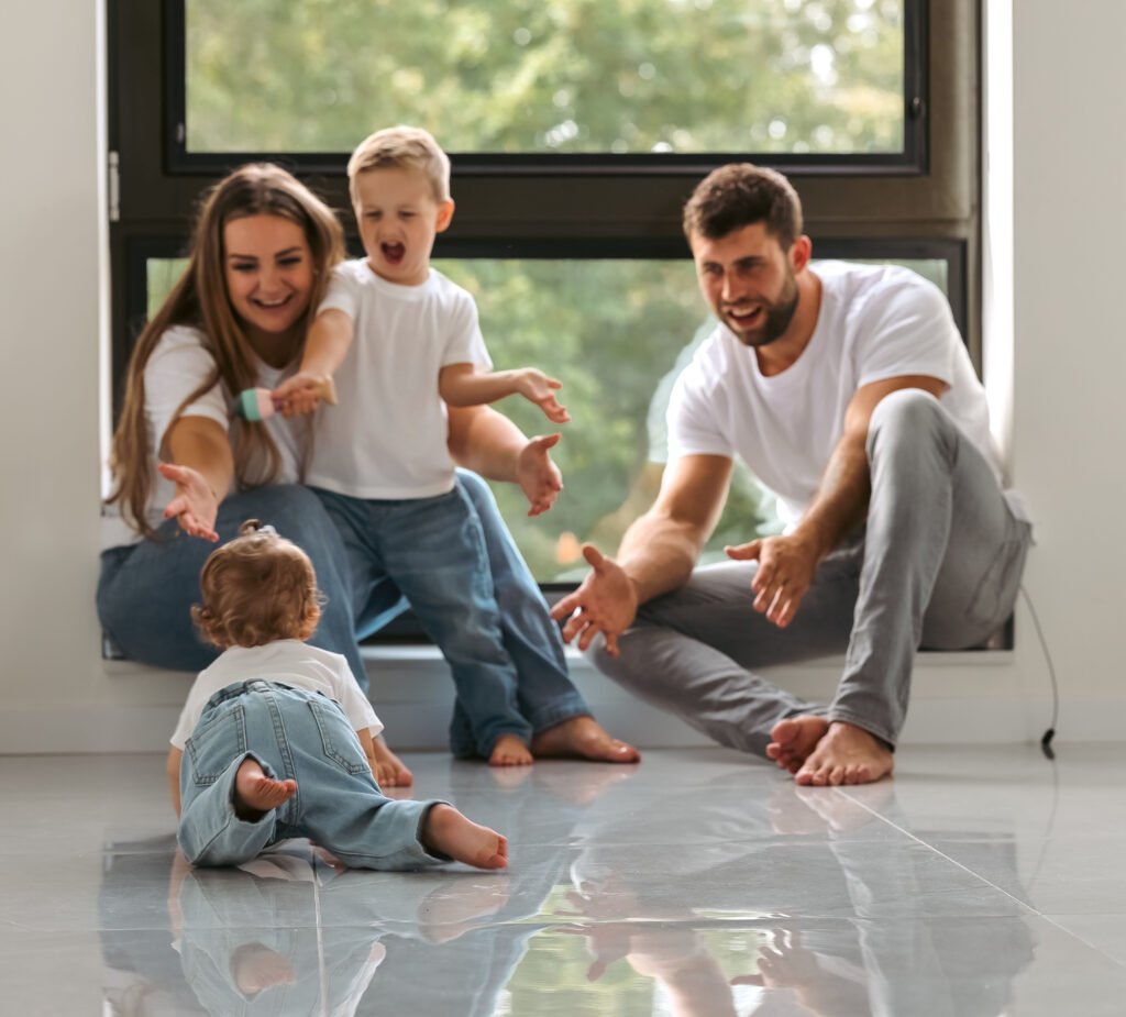 Baby crawling toward parents and older brother during a natural-light family session.