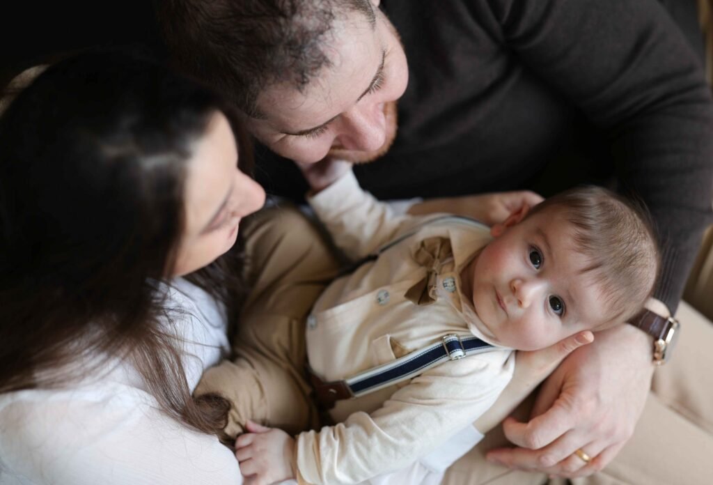 Parents cuddling their baby boy during a warm and intimate lifestyle family session.