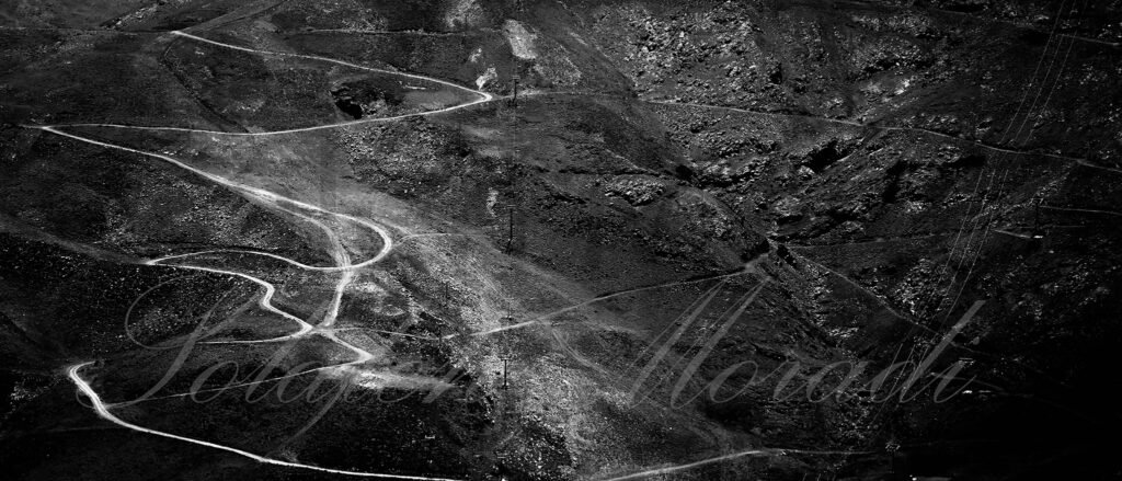 Aerial black and white image of winding mountain paths