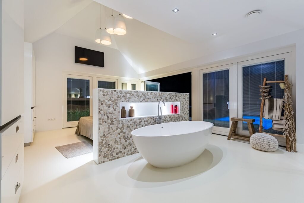Bright open bathroom suite with freestanding bathtub and stone accent wall in The Hague home