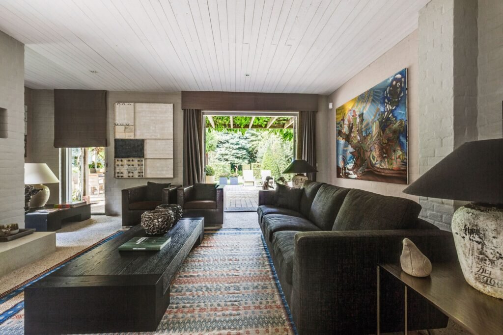Stylish living room with modern art and open view to a landscaped garden in The Hague.