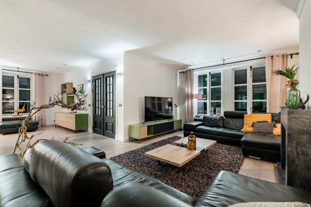 Luxury modern living room with black leather sofas and warm interior lighting in The Hague