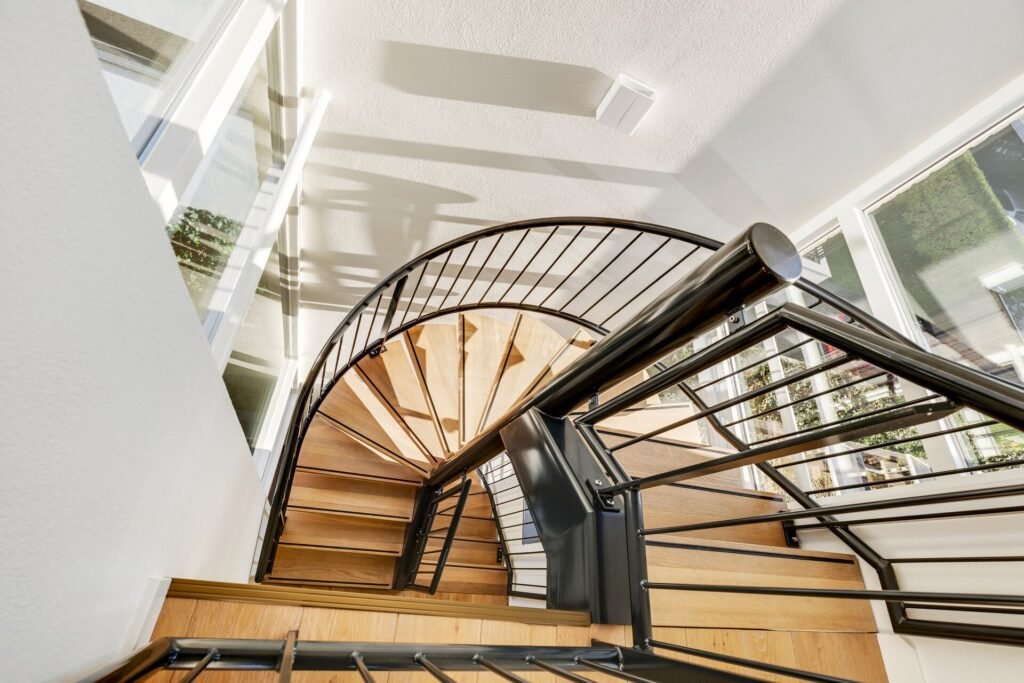 Spiral staircase with wooden steps and black metal railing in The Hague home