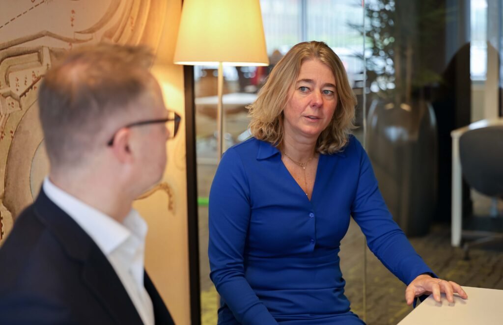 Business discussion between two colleagues at a table in an office in The Hague