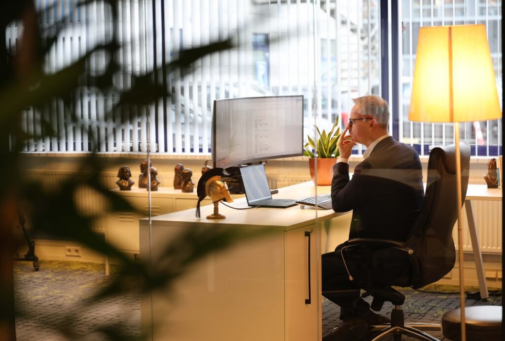 Executive man working at a desk behind a computer screen in a professional office in The Hague